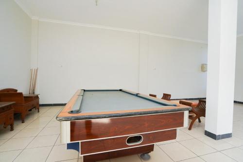 a pool table in the middle of a room at Hotel O Graha Marina in Surabaya