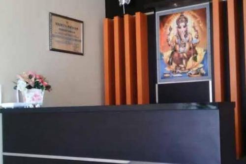 a counter with a picture of a man on the wall at Hotel O Lembah Sriti Homestay Near Sirkuit Motor Cross Internasional 459 Lantan in Labuan Lombok