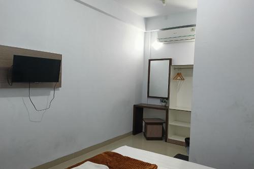 a bedroom with a bed and a tv and a mirror at Hotel O Kost Pak Dahlan Near Modern Estate in Sungguminasa