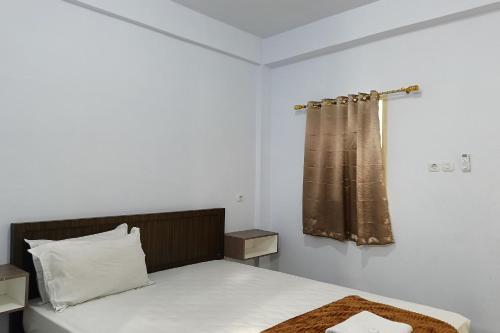 a bedroom with a bed and a shower curtain at Hotel O Kost Pak Dahlan Near Modern Estate in Sungguminasa