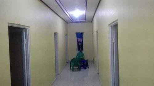 a hallway with a room with chairs and a ceiling at Hotel O Wisma Nadira Near SPBU PT. Trijaya Pugung PENENGAHAN in Karbang