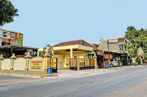 an empty street with a building on the side of the road at OYO 91599 Penginapan Mutiara Madiun in Madiun