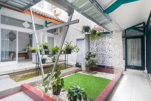 Un jardín interior con césped en medio de una casa. en OYO Life 3055 Rumah Enin, en Bandung
