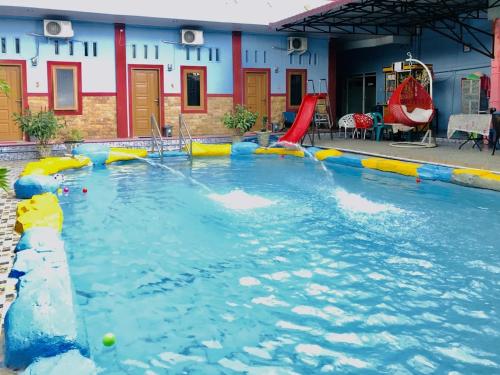einem Pool mit Wasserrutsche in einem Gebäude in der Unterkunft OYO 3334 Ratu Residence in Medan