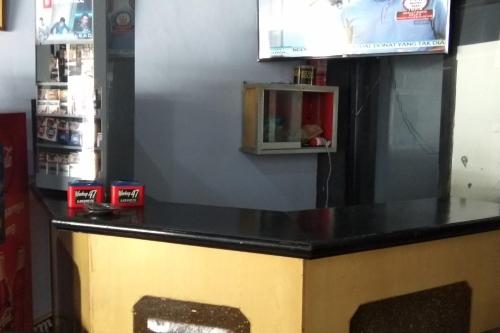 a bar in a restaurant with a black counter top at Hotel O Homestay 47 Latanete Near Living Plaza in Makassar