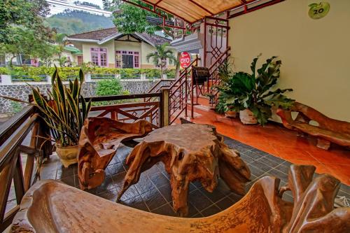 a living room with a wooden table and a bench at Hotel O Villa Papada in Batu
