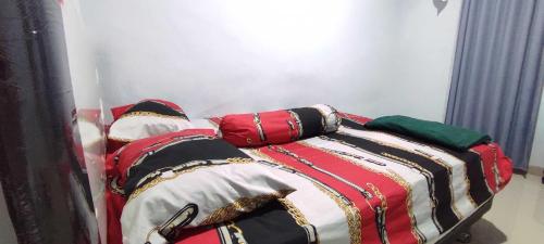 un lit avec des couvertures et des oreillers colorés dessus dans l'établissement Hotel O Penginapan Noval, à Lipukasi