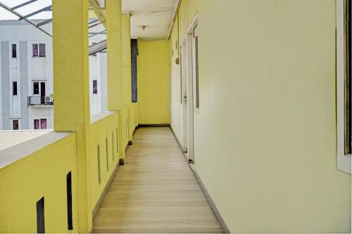 an empty hallway of a building with yellow and white walls at OYO 93328 Graha Citra Syariah in Karajaan