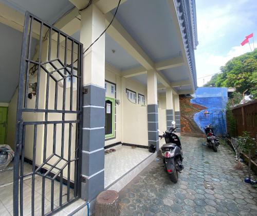 two motorcycles parked outside of a building with a gate at OYO Life 93401 Kos Putri Alamanda Syariah in Tjakranegara