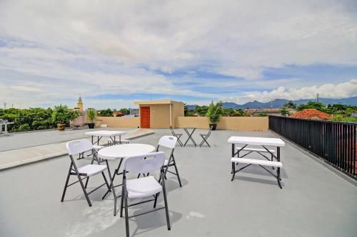 a patio with tables and chairs on a roof at Hotel O Madania Guesthouse Syariah in Mataram