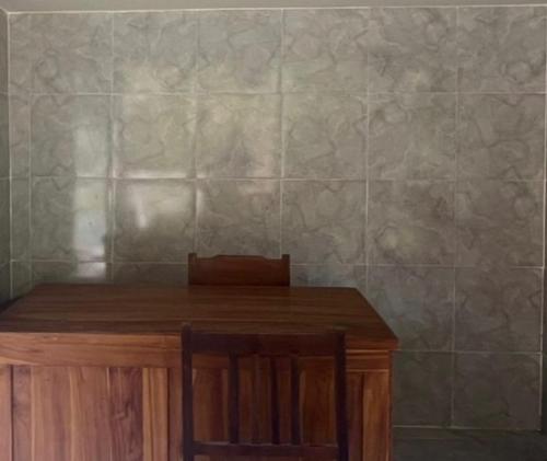 a wooden table with two chairs and a tiled wall at OYO Life 93401 Kos Putri Alamanda Syariah in Tjakranegara