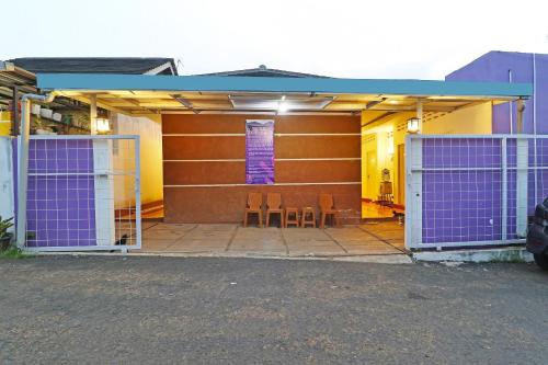 a garage with purple doors and two chairs in it at OYO Life 91504 De Vila Ungu Syariah in Ciamis