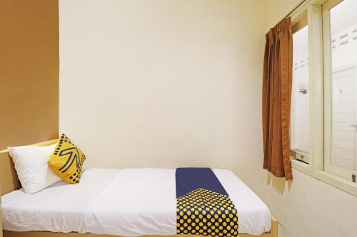 a bedroom with a bed and a window at OYO Life 91504 De Vila Ungu Syariah in Ciamis