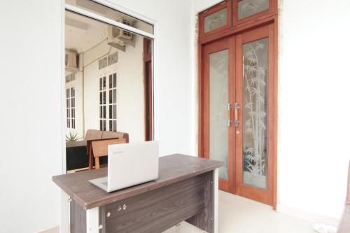a desk with a laptop on it in a room at Hotel O Ratha Guest House Syariah in Pekanbaru