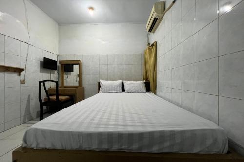 a bedroom with a white bed in a room at Hotel O Kost Aisyah Near Citra Grand Galesong City(Pattalassang) in Bilibili
