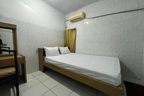 a small room with a bed and a mirror at Hotel O Kost Aisyah Near Citra Grand Galesong City(Pattalassang) in Bilibili