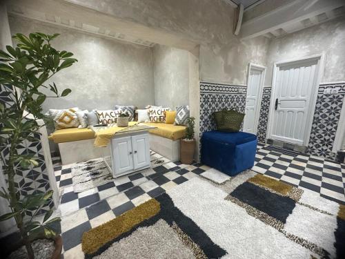 Habitación con sofá amarillo y taburete azul en Mini Style Riad in the heart of the Medina, en Essaouira