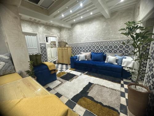 Una sala de estar con un sofá azul y una alfombra. en Mini Style Riad in the heart of the Medina, en Essaouira