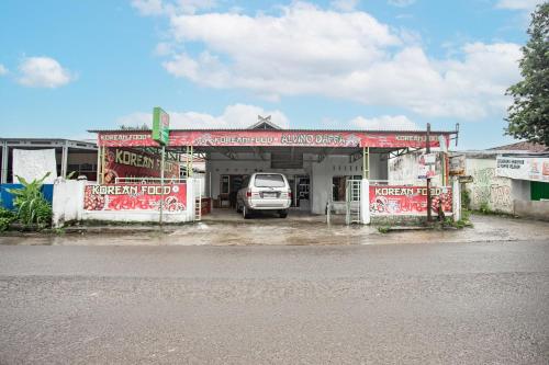 une voiture est garée dans une station-service dans l'établissement Hotel O Penginapan Tulimario Syariah, à Jambi