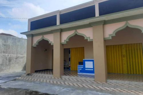 a building with yellow and blue doors on it at Hotel O Syagita Kos & Penginapan Syariah in Yogyakarta