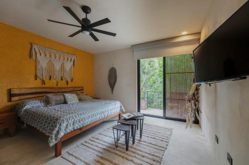 een slaapkamer met een bed en een plafondventilator bij Charming Tulum Getaway in Prime Location in Tulum