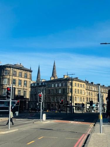 une rue urbaine avec des bâtiments et des feux rouges dans l'établissement Haymarket Centro , Flat familiar quarto privativo banheiro compartilhado, à Édimbourg