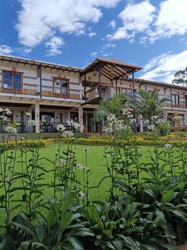 a large building with a lawn in front of it at Hotel Pliosaurio Campestre in Villa de Leyva