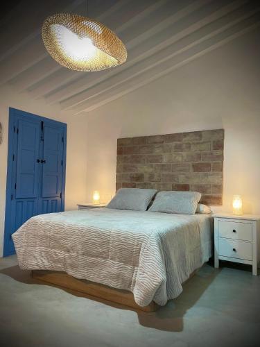 a bedroom with a large bed and a brick wall at Casa Alta 22 in Frigiliana
