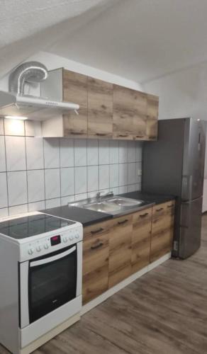 a kitchen with a stove and a sink and a refrigerator at Bajkowe Zacisze - Basen, Ping-pong, Bilard in Mielno