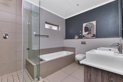 ein Badezimmer mit Waschbecken, Toilette und Dusche in der Unterkunft Modern Comfort Retreat in Central Sandton with WiFi , Gym and Pool in Johannesburg