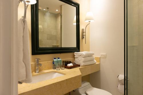 a bathroom with a sink and a toilet and a mirror at Hotel Caribe by Faranda Grand, a member of Radisson Individuals in Cartagena de Indias