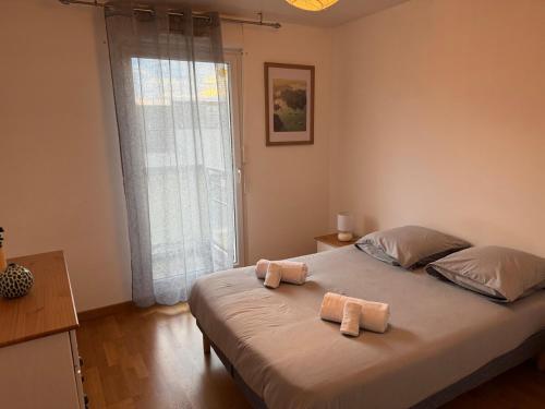 une chambre avec un lit avec deux serviettes dessus dans l'établissement Spacious 3-room, 6-person apartment in Villeurbanne, à Villeurbanne