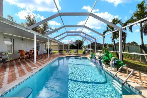 an indoor swimming pool with a clear roof and a large swimming poolvisor at Pool Modern South West Cape Casa Del Mar in Cape Coral