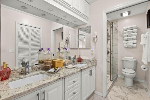 a bathroom with two sinks and a toilet and a shower at Pool Modern South West Cape Casa Del Mar in Cape Coral