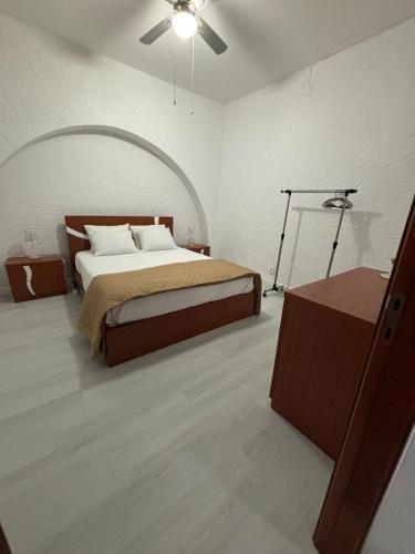 a bedroom with a large bed with a ceiling fan at Casa da Praça II in Vila Nova