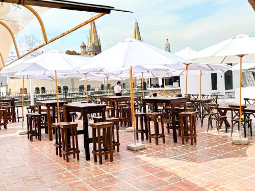 a group of tables and chairs with umbrellas at Hotel Frances in Guadalajara