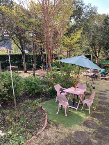 a table with two chairs and an umbrella at ＯＫＵＮＯ ＩＥ in Oshima