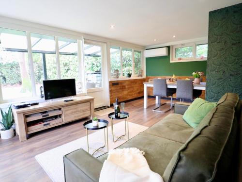 a living room with a couch and a tv at Sonnig Bungalow in Bovenwezet