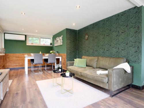 a living room with a couch and a table at Sonnig Bungalow in Bovenwezet