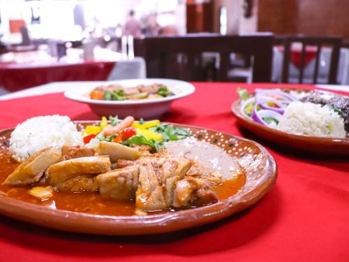 a red table with a plate of food on it at Hotel Frances in Guadalajara
