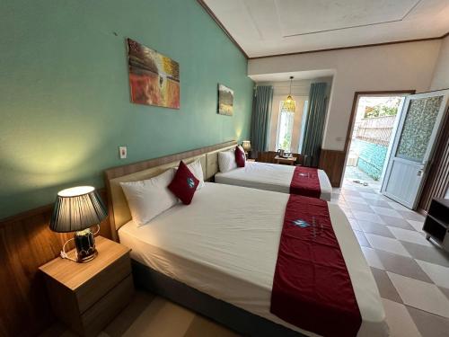 a bedroom with a bed and a lamp and a window at Minh Chau Beach Resort in Quang Ninh