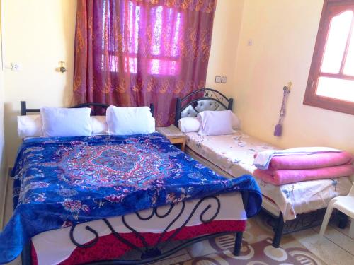 a bedroom with two beds and a window at Tata Guest House in Tatta