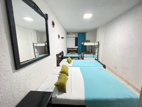 two beds in a room with a mirror at Hotel Boutique San Sara Santa Marta Terminal in Santa Marta