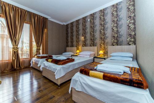um quarto com 3 camas e uma janela em HOTEL GUGLUX &WINE CELLAR em Tel Avi