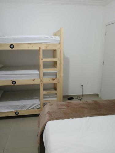 a room with two bunk beds and a bed at Ô de casa hostel in Balneário Camboriú