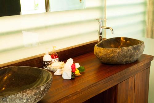 uma casa de banho com 2 lavatórios e toalhas num balcão de madeira em Oxygen Jungle Villas & Spa em Uvita