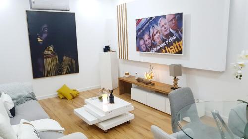 a white living room with a table and a couch at Luxe-Design Imperio II- Petit Déjeuner 5min de la Mer in Praia