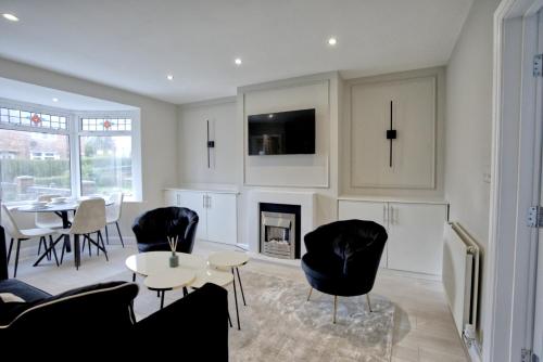 a living room with a table and chairs and a fireplace at Luxury Harborne Home, Perfect for Contractors & Families 5 Mins from QE & Uni in Birmingham
