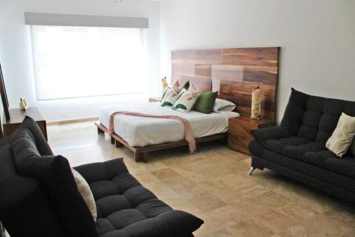 a living room with a bed and two couches at Departamento en Ixtapa PORTO VENTO S201 in Ixtapa