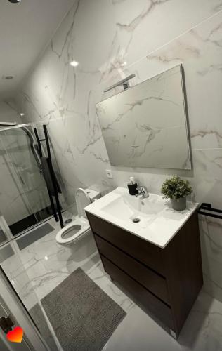 a bathroom with a sink and a toilet and a mirror at Best Gerês village in São Pedro